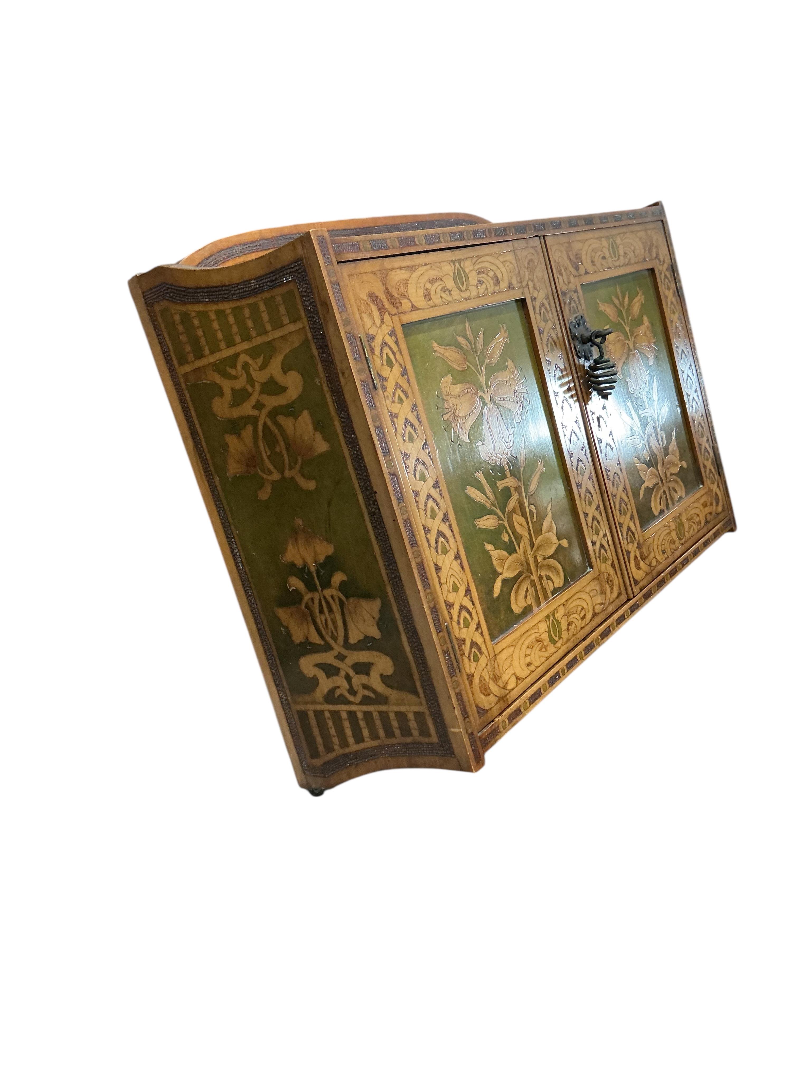 An Art Nouveau poker work two door wall cabinet, width 61cm, depth 21cm, height 52cm